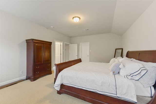 bedroom featuring vaulted ceiling and light colored carpet