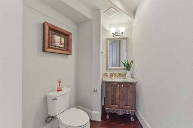 bathroom with wood-type flooring, vanity, and toilet