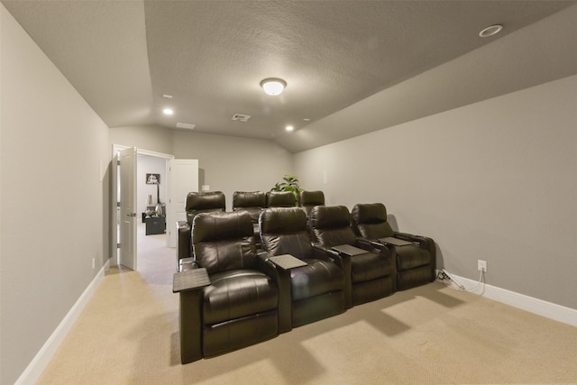 cinema room featuring vaulted ceiling, light carpet, and a textured ceiling