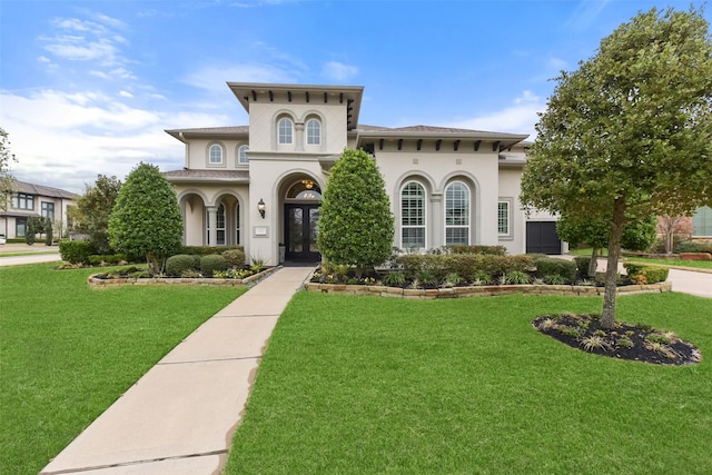 mediterranean / spanish house with a front yard and french doors