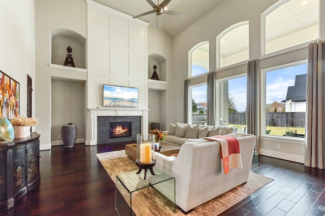 living room with a high ceiling, dark hardwood / wood-style floors, and ceiling fan