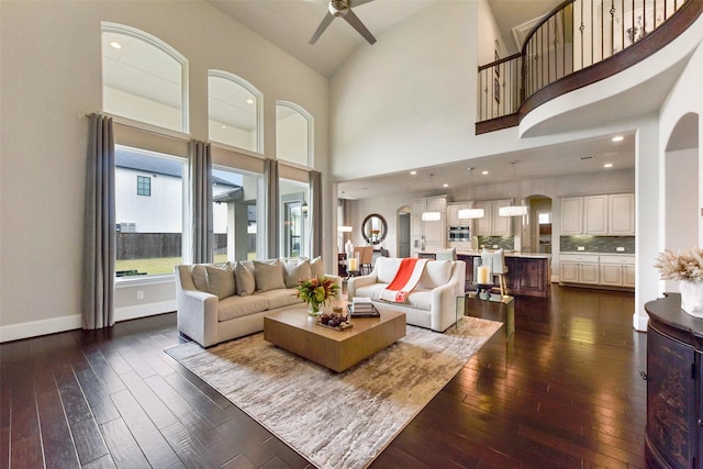 living room featuring dark wood-type flooring and ceiling fan