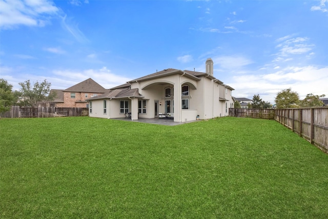 rear view of house featuring a patio area and a lawn