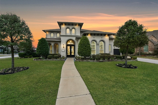 view of front facade featuring a lawn and french doors