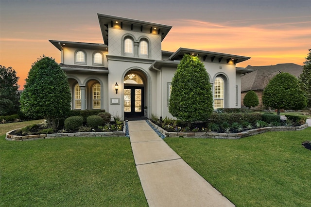 view of front of property featuring a lawn and french doors