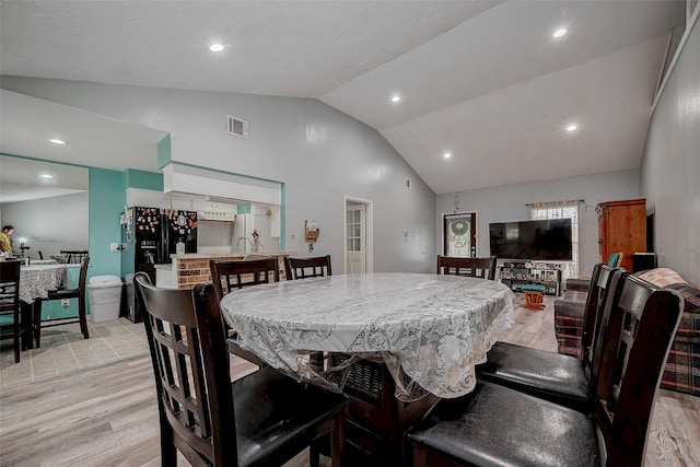 dining room featuring vaulted ceiling and light hardwood / wood-style floors