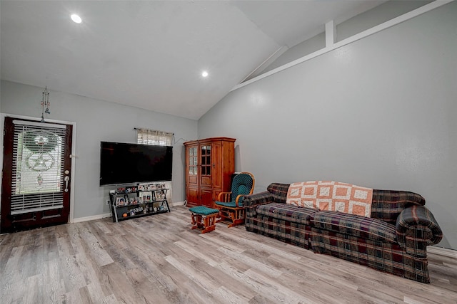 living room with high vaulted ceiling and light hardwood / wood-style floors