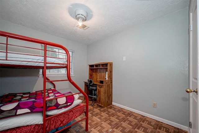 bedroom featuring dark parquet flooring and a textured ceiling