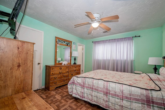 bedroom featuring ceiling fan, a textured ceiling, and dark parquet floors