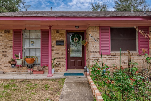 view of exterior entry featuring covered porch