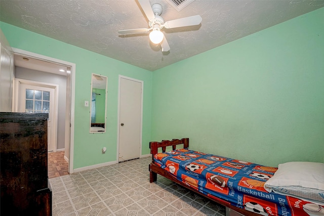 bedroom featuring ceiling fan and a textured ceiling