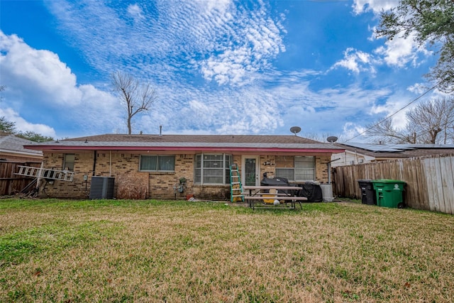 back of property featuring central AC unit and a yard