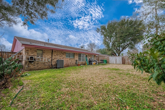 back of house featuring central AC and a lawn