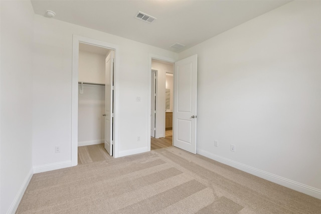 16119 Rustling Woods Rd, Conroe, TX 77302 - unfurnished bedroom featuring light carpet, a spacious closet, and a closet