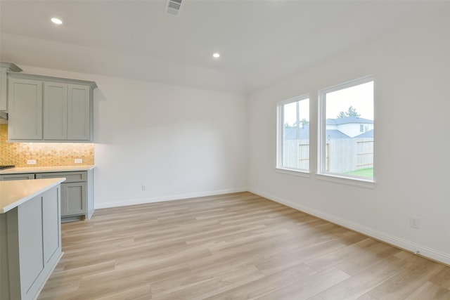 16119 Rustling Woods Rd, Conroe, TX 77302 - kitchen featuring light countertops, gray cabinets, light wood-style flooring, backsplash, and recessed lighting