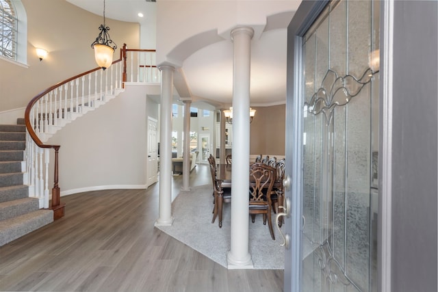 dining space with hardwood / wood-style flooring and decorative columns