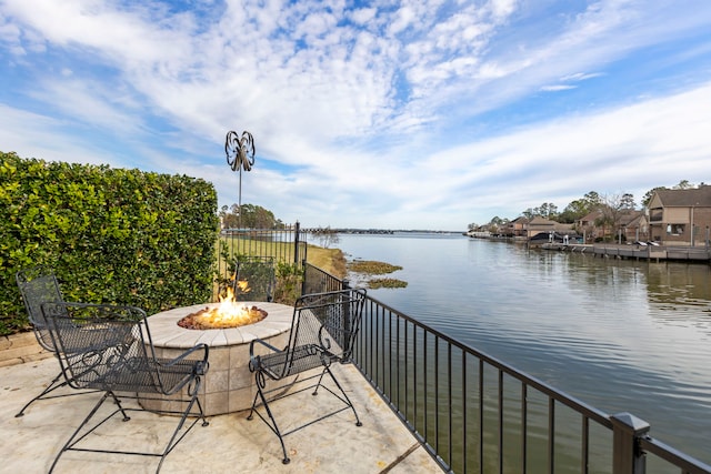 balcony with a water view and a fire pit