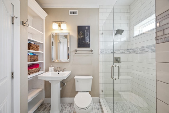 bathroom with tile patterned floors, ornamental molding, toilet, and a shower with door