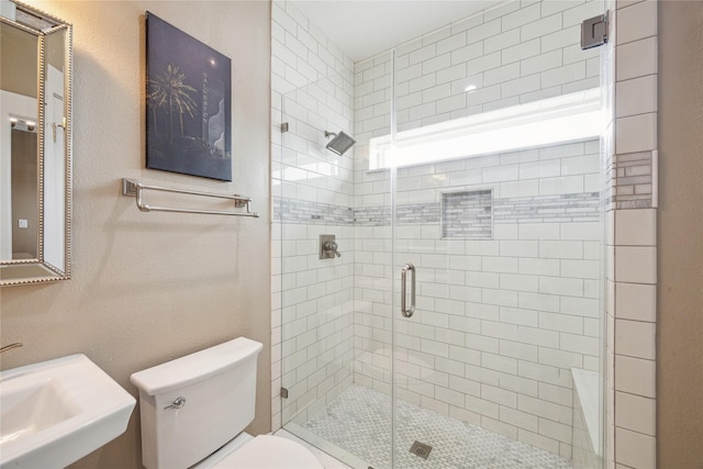 bathroom with sink, an enclosed shower, and toilet
