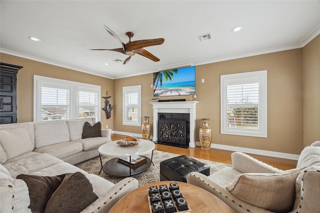 living room with crown molding, wood-type flooring, and ceiling fan