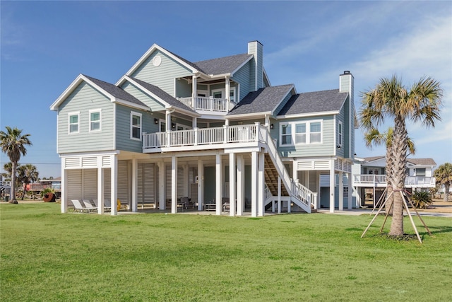 rear view of property with a balcony and a lawn