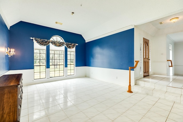 spare room with vaulted ceiling and light tile patterned floors