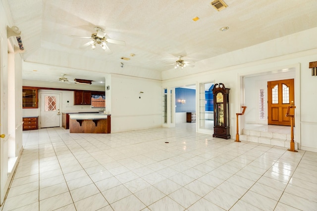 unfurnished living room with light tile patterned floors and ceiling fan