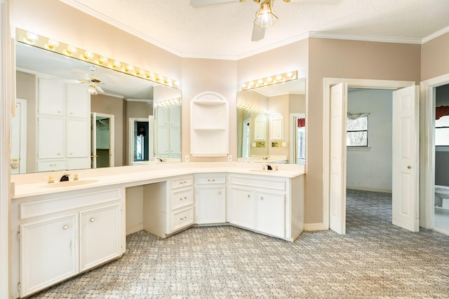 bathroom featuring ornamental molding, a textured ceiling, vanity, and ceiling fan