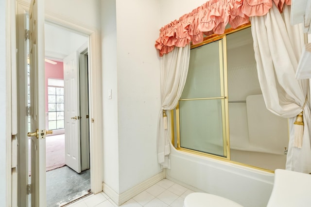 bathroom with toilet and shower / bath combination with glass door