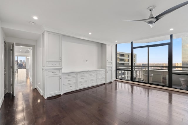 unfurnished room with floor to ceiling windows, dark hardwood / wood-style floors, and ceiling fan