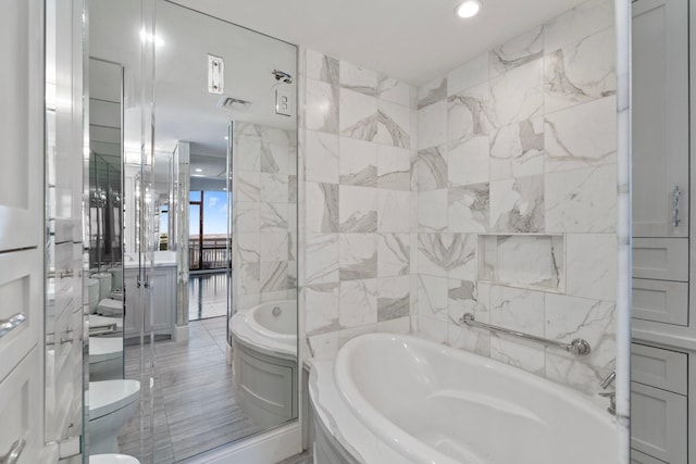 bathroom with a tub, tile walls, and toilet