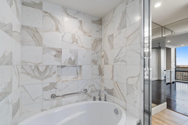 bathroom with a washtub and wood-type flooring