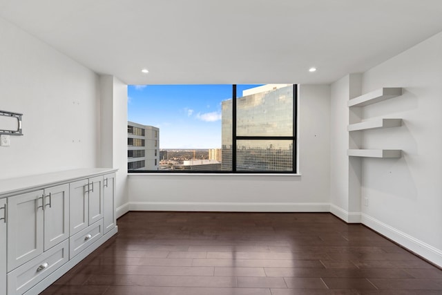 empty room with dark hardwood / wood-style flooring