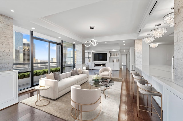 living room with a raised ceiling, crown molding, dark hardwood / wood-style flooring, and expansive windows