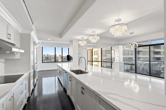 kitchen featuring white cabinetry, sink, pendant lighting, and black electric stovetop