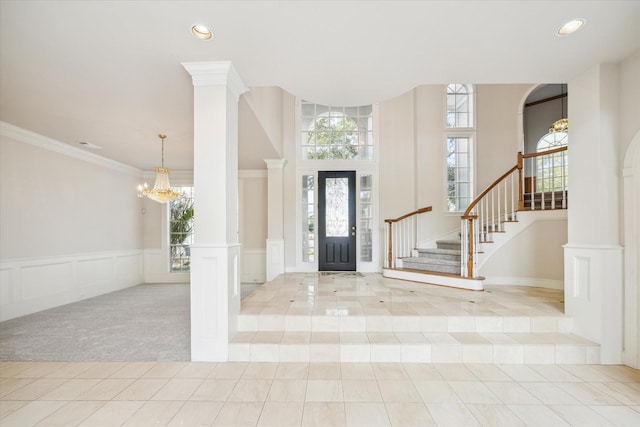 foyer with light tile patterned flooring, ornamental molding, and ornate columns