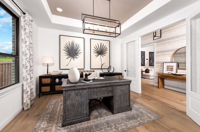 home office with hardwood / wood-style flooring and a notable chandelier