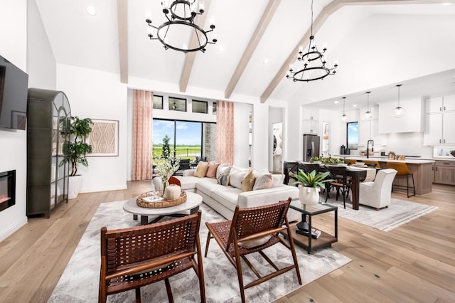 living room with beamed ceiling, light hardwood / wood-style floors, high vaulted ceiling, and a notable chandelier