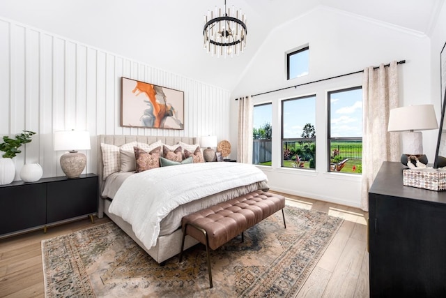 bedroom featuring light hardwood / wood-style flooring, high vaulted ceiling, and a chandelier