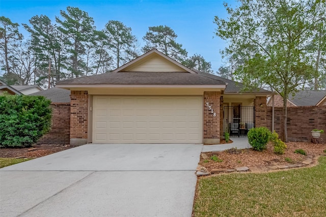 single story home with concrete driveway, brick siding, and an attached garage