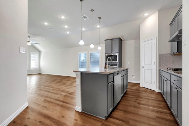 kitchen featuring gray cabinets, an island with sink, sink, hanging light fixtures, and exhaust hood