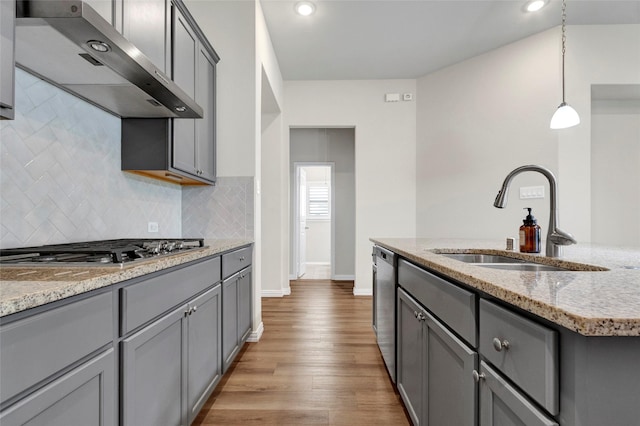 kitchen with pendant lighting, sink, stainless steel appliances, light stone countertops, and exhaust hood