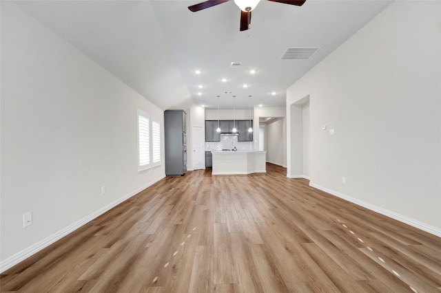 unfurnished living room featuring ceiling fan, lofted ceiling, and light wood-type flooring