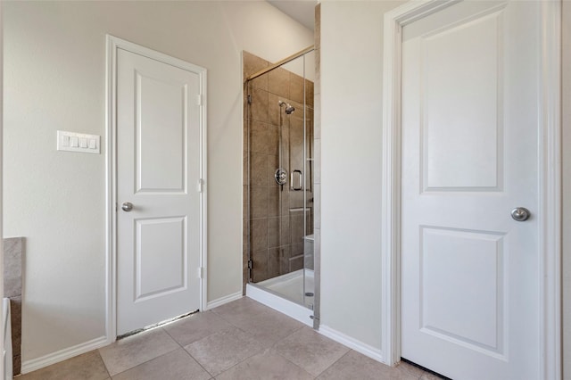 bathroom with an enclosed shower and tile patterned floors