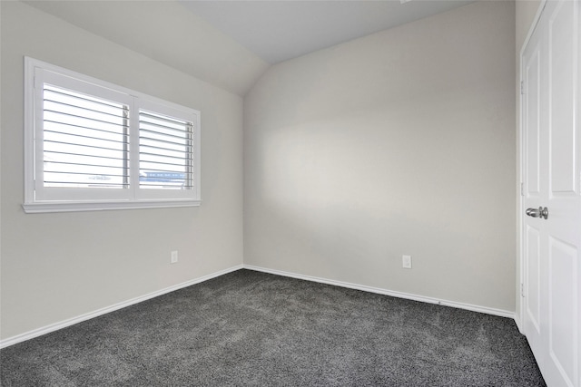 carpeted spare room with vaulted ceiling