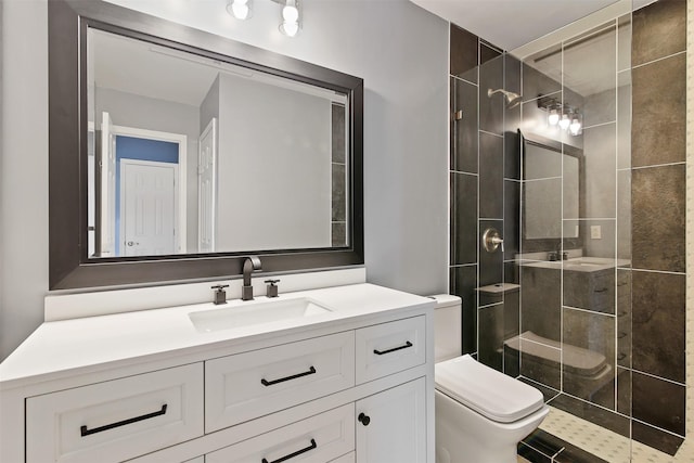 full bath with tiled shower, vanity, and toilet