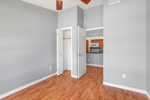 unfurnished bedroom with visible vents, baseboards, ceiling fan, light wood-type flooring, and a closet