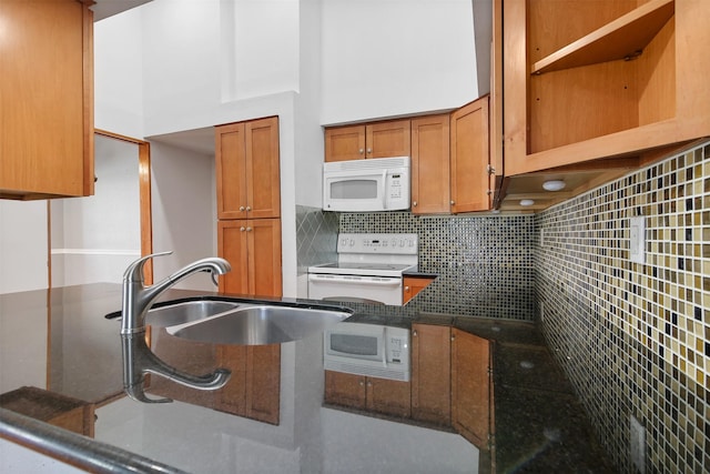 kitchen with brown cabinets, open shelves, decorative backsplash, a sink, and white appliances