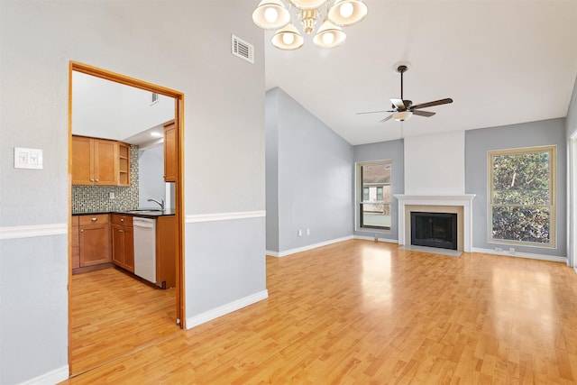 unfurnished living room with light wood-type flooring, a healthy amount of sunlight, a fireplace, and visible vents