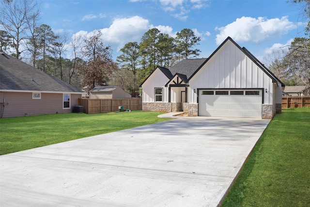 view of front of property with a garage, central AC, and a front lawn